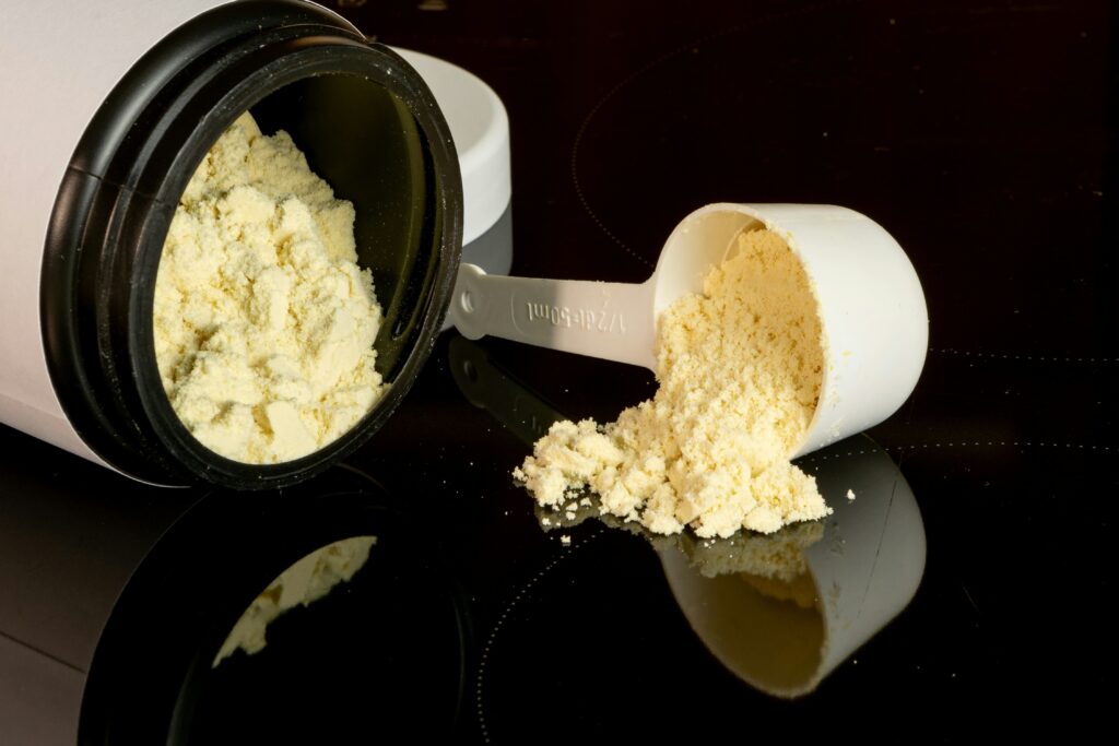 Protein powder and measuring scoop for post-workout recovery and muscle building.